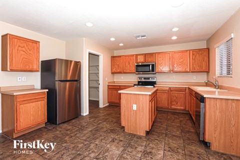 A kitchen with wooden cabinets and a stainless steel refrigerator.