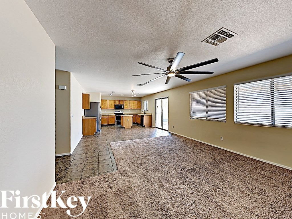 A spacious room with a fan and a dining table.