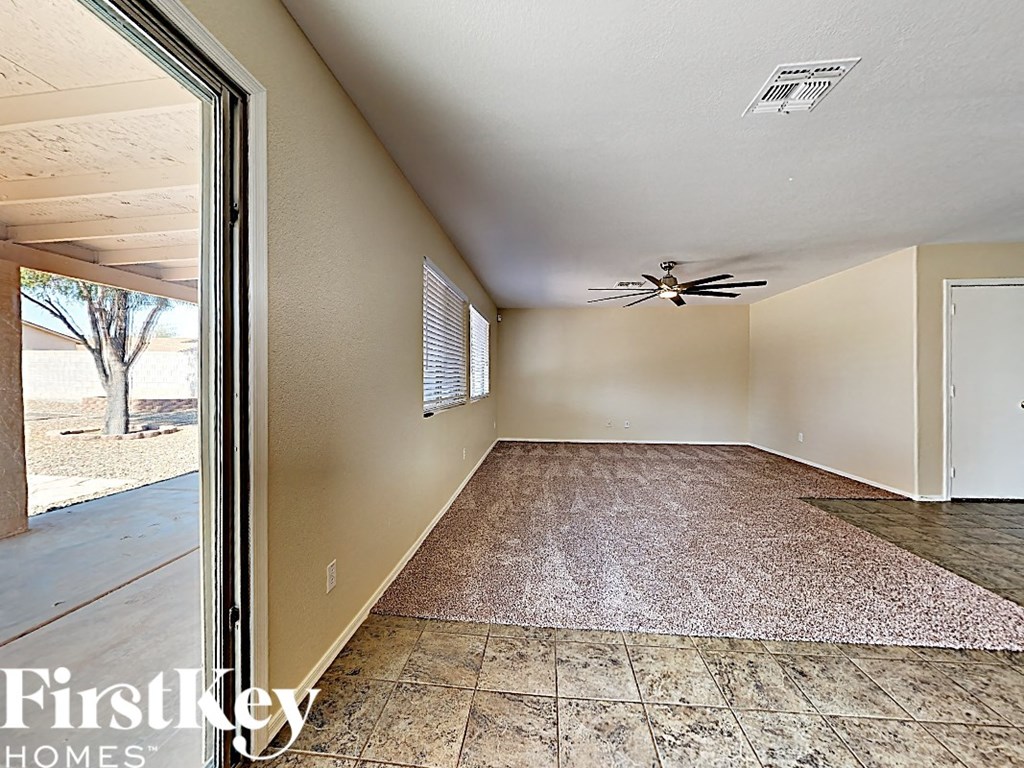 A room with a ceiling fan and a door.