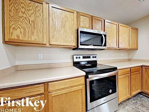 A kitchen with wooden cabinets and a stove top oven.