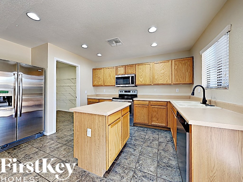 A kitchen with wooden cabinets and a refrigerator.
