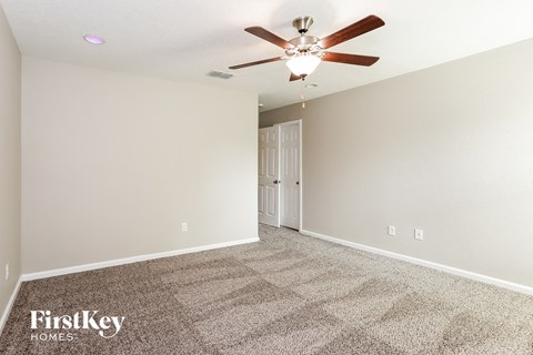 a living room with carpet and a ceiling fan