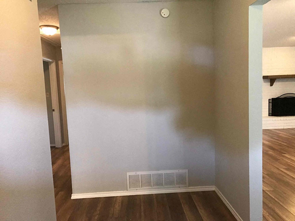 an empty room with a wall and a heater