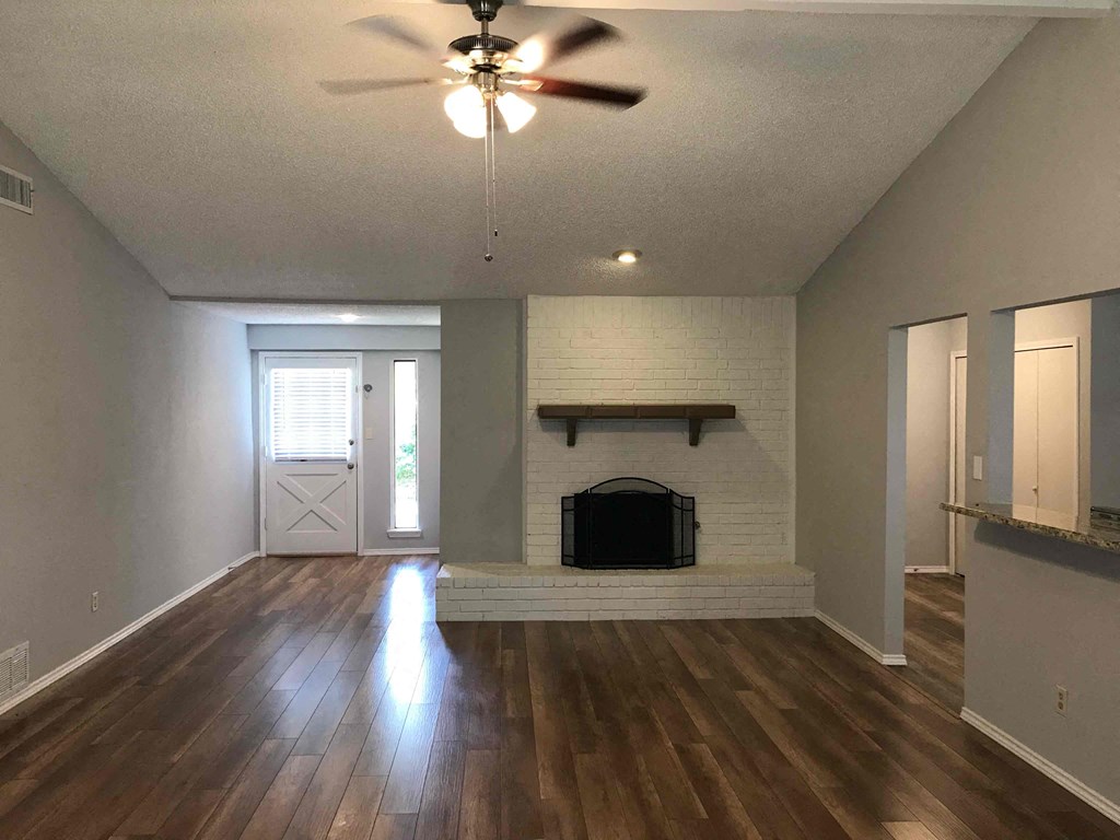 a living room with a fireplace and a ceiling fan