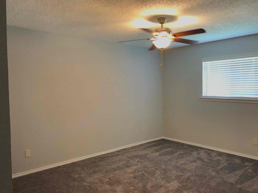 a bedroom with a ceiling fan and a window