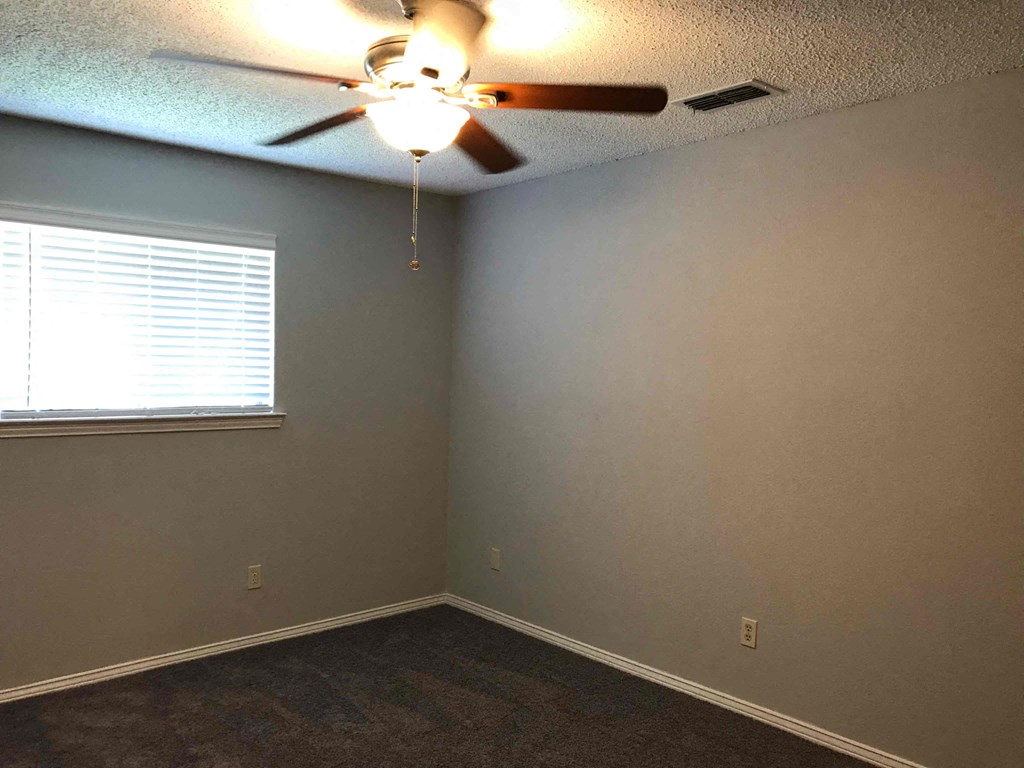 a bedroom with a ceiling fan and a window