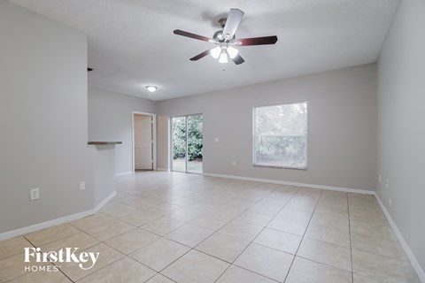 A spacious room with a ceiling fan and tiled flooring.