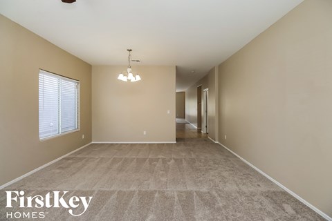 a spacious living room with beige walls and a carpeted floor