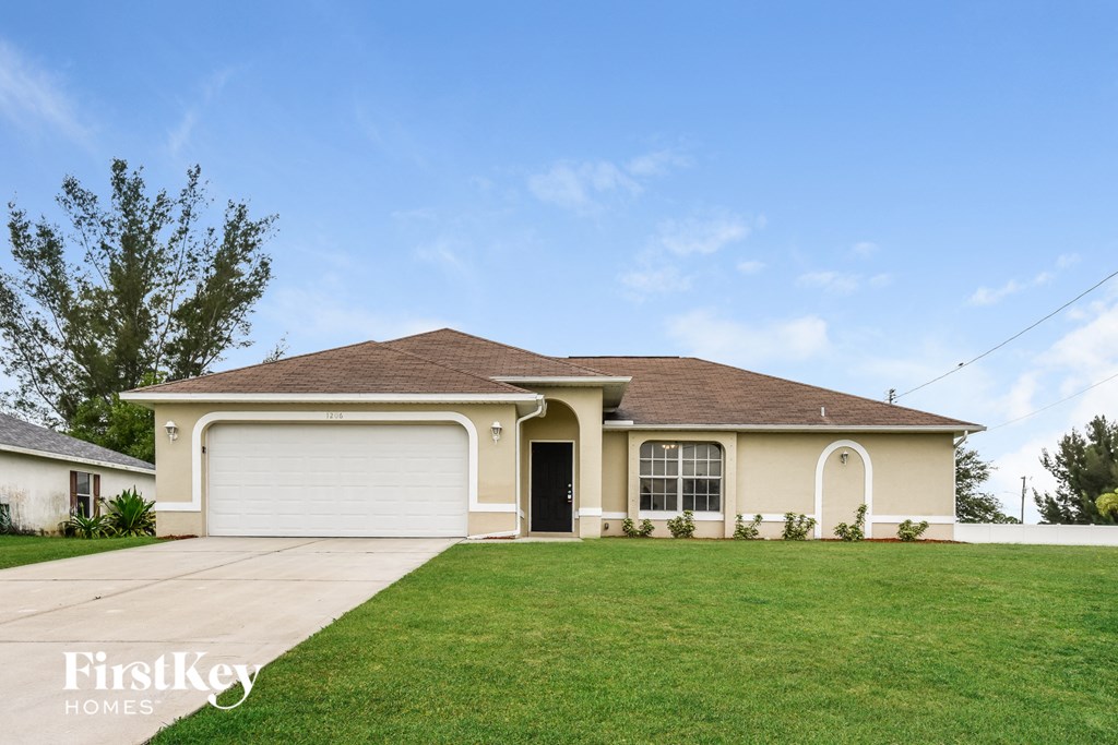 a beige house with a lawn in front of it