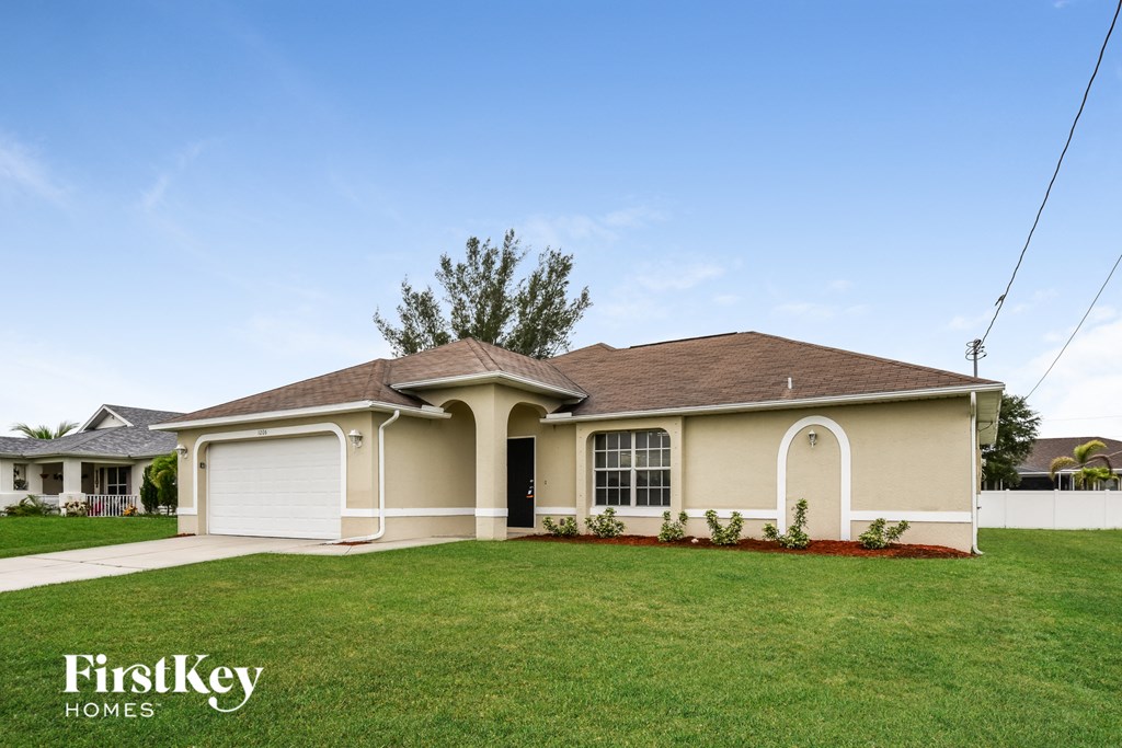 a beige house with a lawn in front of it