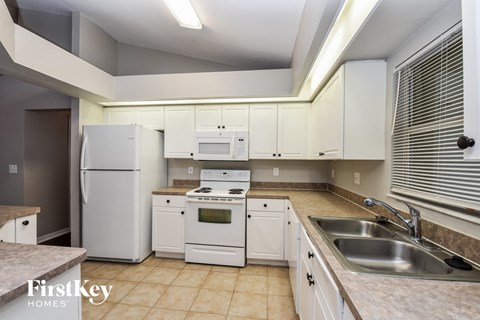 a kitchen with white appliances and white cabinets