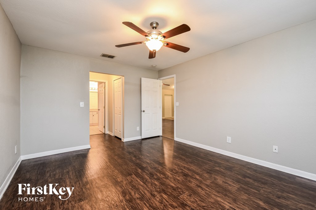 the living room of an empty house with a ceiling fan