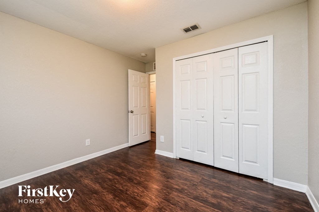 a bedroom with two closets and a door to a hallway