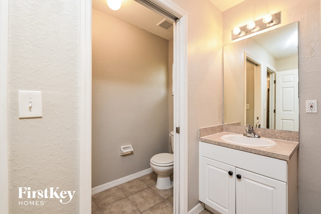 a bathroom with a toilet and a sink and a mirror