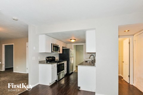 A kitchen with white cabinets and appliances in a modern home.