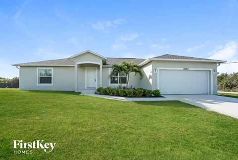 a white house with a lawn and a garage