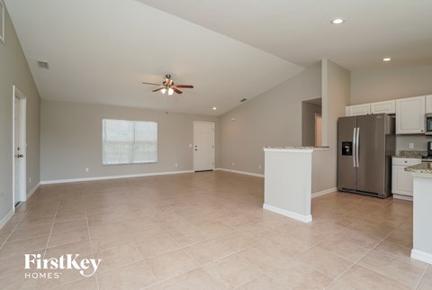 an empty kitchen and living room with a ceiling fan