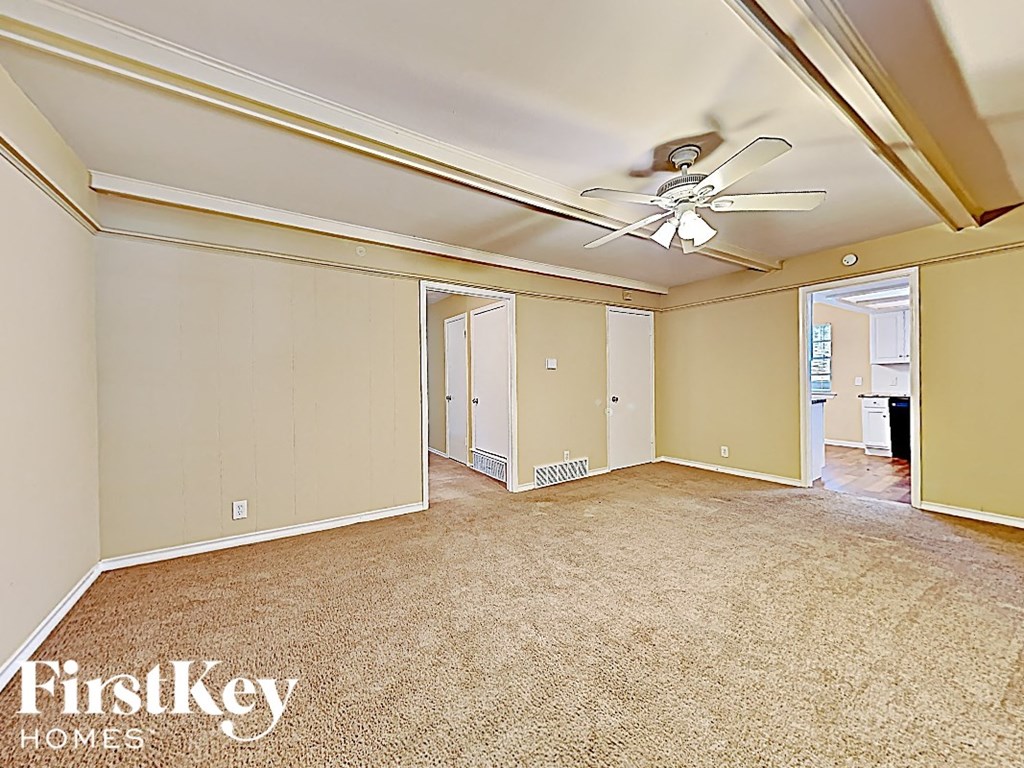 an empty living room with a ceiling fan