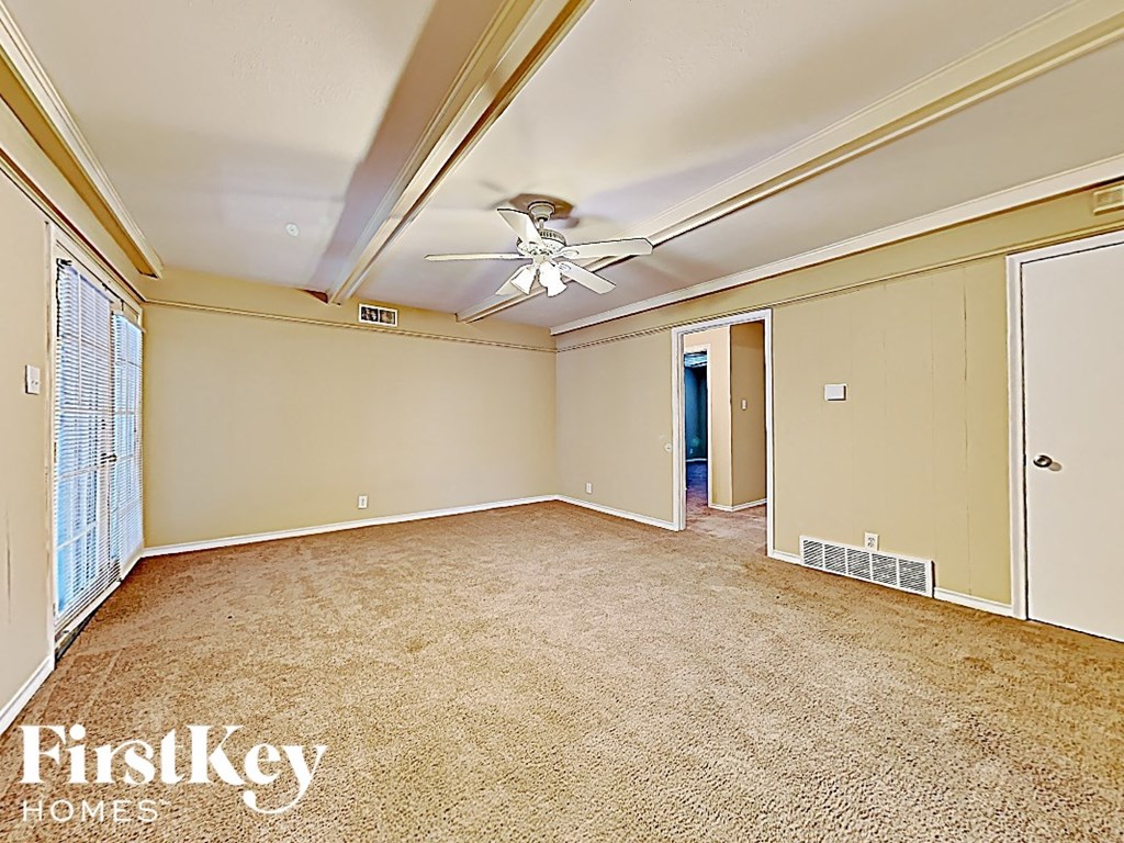an empty living room with a ceiling fan