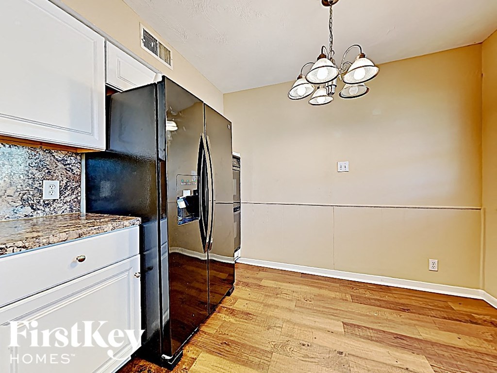 a kitchen with a stainless steel refrigerator and a wooden floor