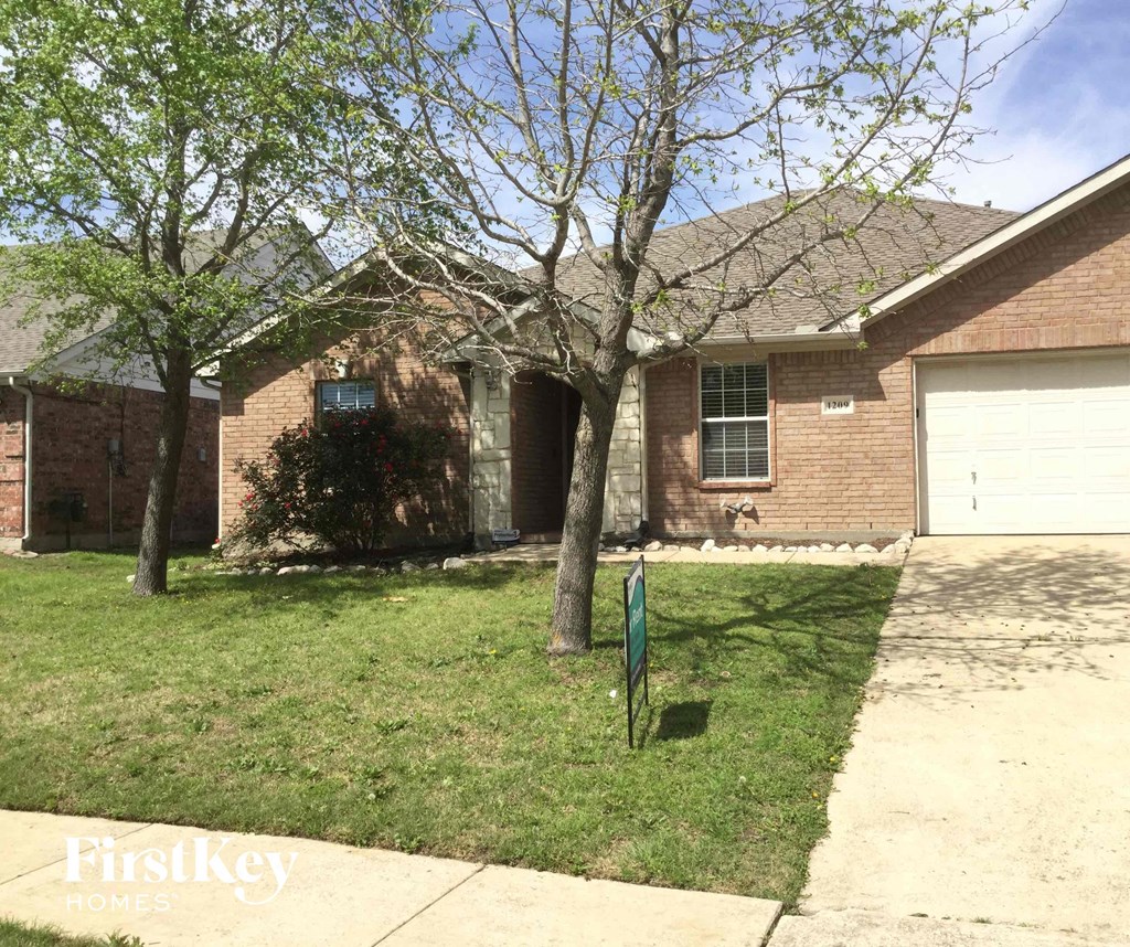 a house with a yard and a yard sign in front of it