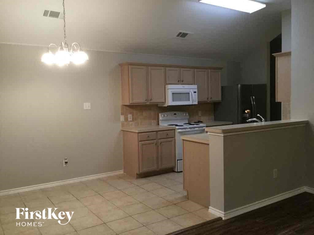 an empty kitchen with wooden cabinets and a counter top