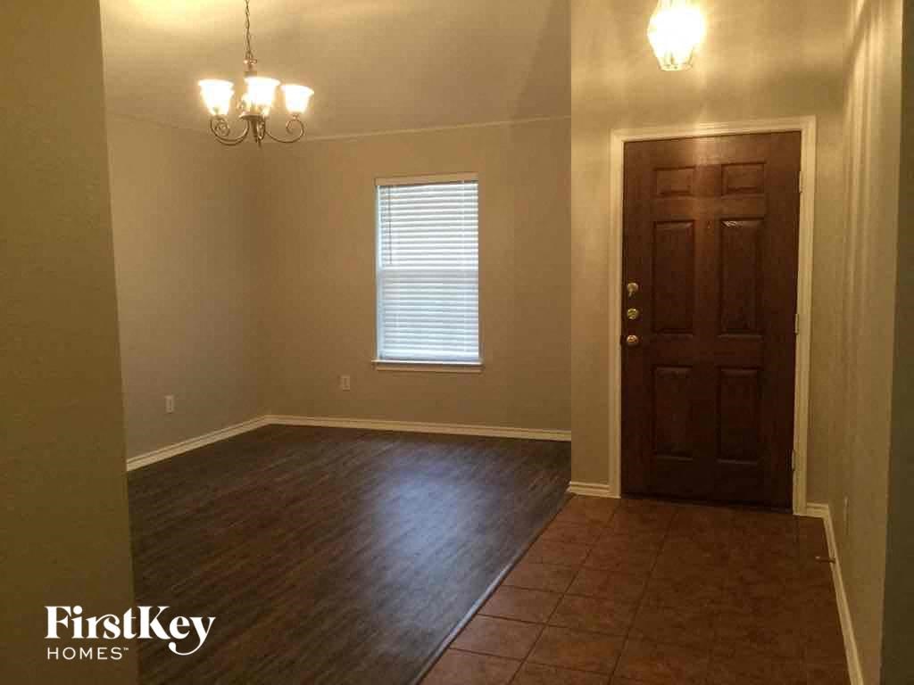an empty dining room with a wooden door and tile floor