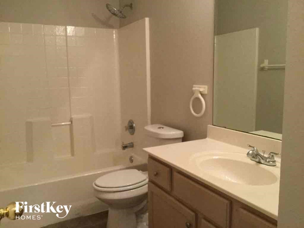 a white bathroom with a sink toilet and shower