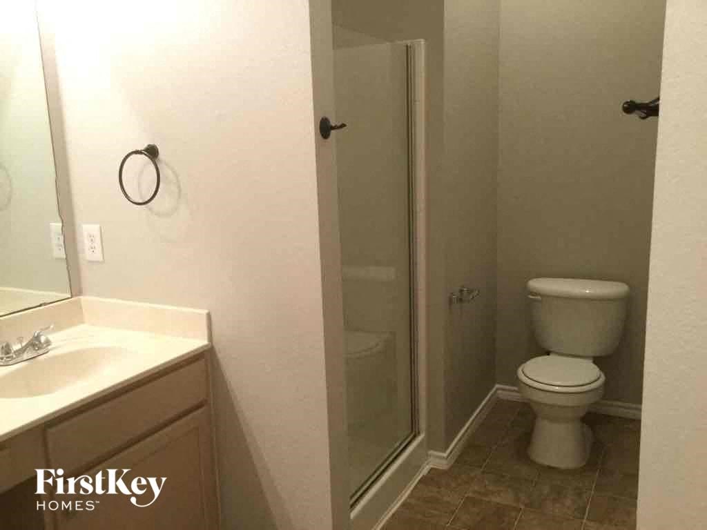 a bathroom with a toilet and a sink and a shower