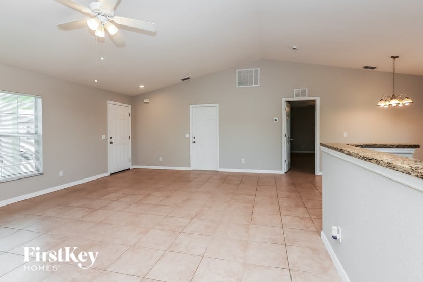A spacious room with a ceiling fan and tiled floor.