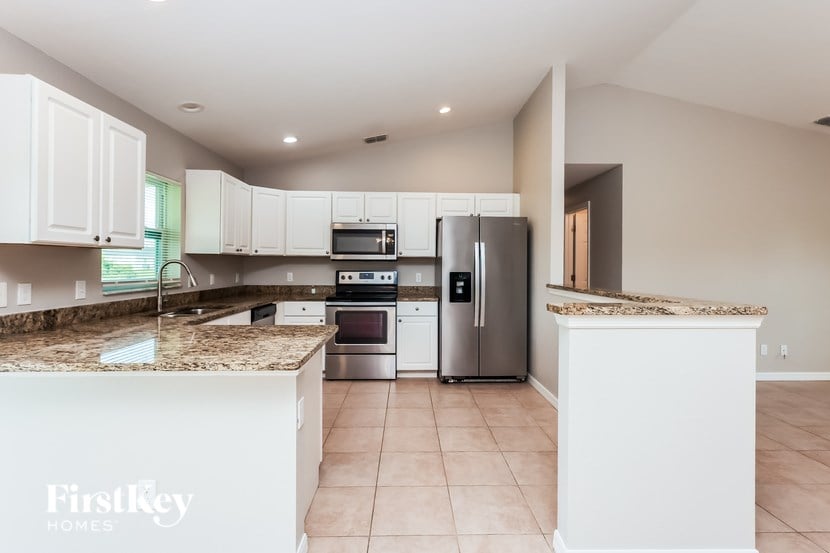 A kitchen with a granite countertop and stainless steel appliances.