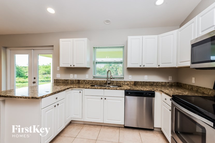 A kitchen with white cabinets and a granite countertop.