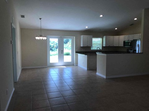 A kitchen with a black counter top and white cabinets.