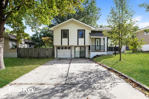 a white house with a white driveway and trees