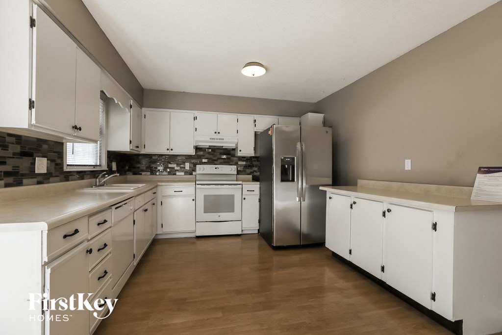 a large kitchen with white cabinets and stainless steel appliances