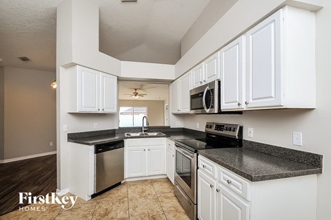 a kitchen with white cabinets and stainless steel appliances