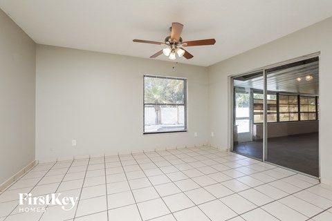 A spacious room with a ceiling fan and sliding glass doors.
