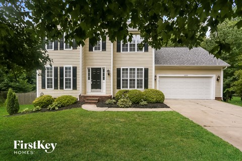 the front of a house with a driveway and a lawn