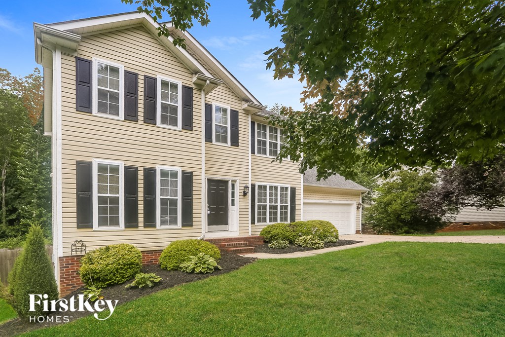 a home with a lawn and a sidewalk in front of it