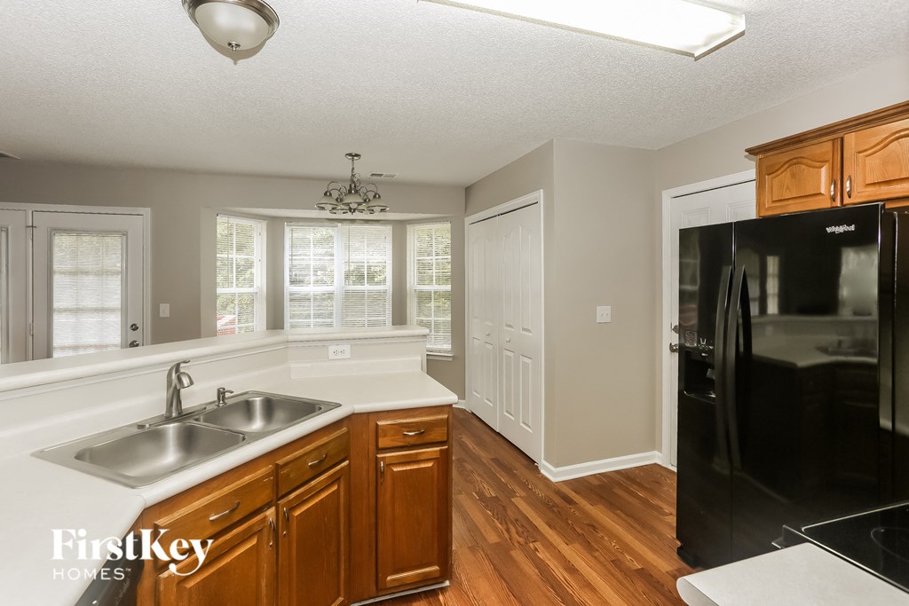 a kitchen with a sink and a black refrigerator