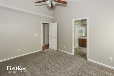 a bedroom with a carpeted floor and a ceiling fan