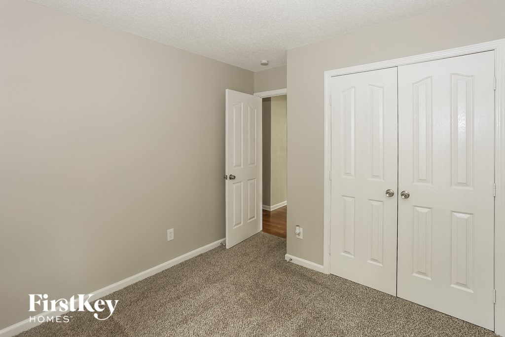 a bedroom with two closets and a door to a hallway