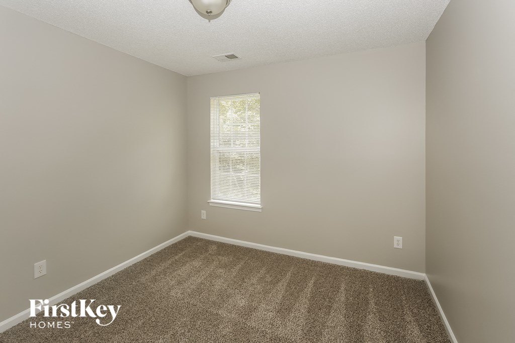 an empty room with carpet and a window