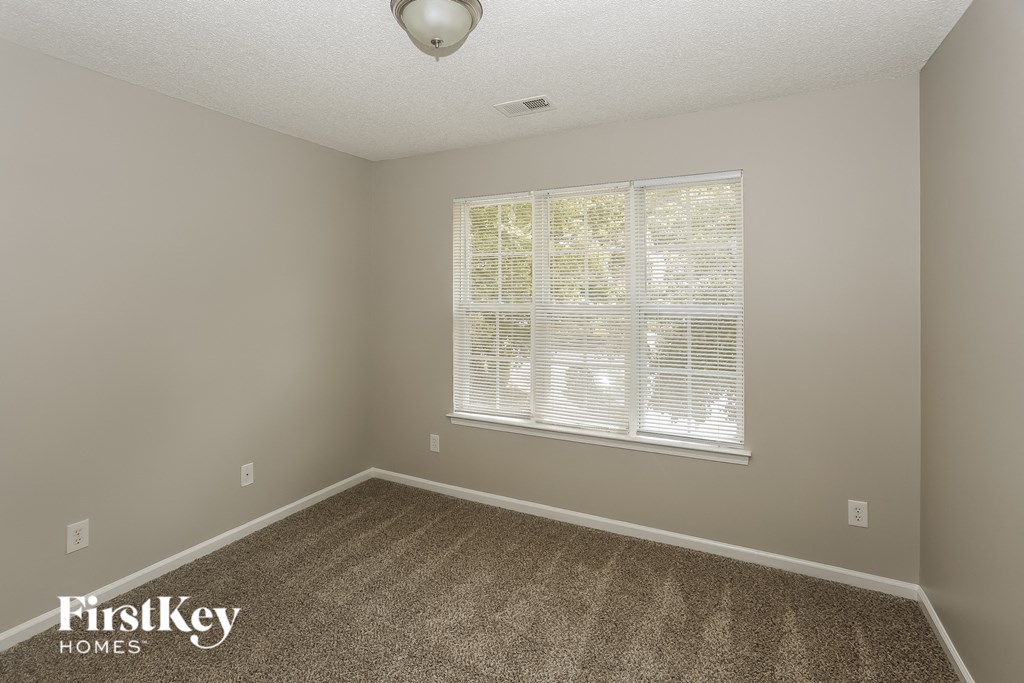 a empty room with carpet and a large window