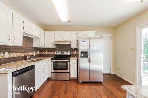a kitchen with white cabinets and stainless steel appliances