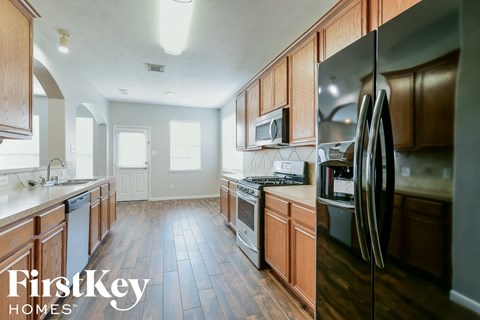 A kitchen with wooden cabinets and a refrigerator.