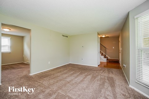 the living room and dining room are spacious with windows and carpeting