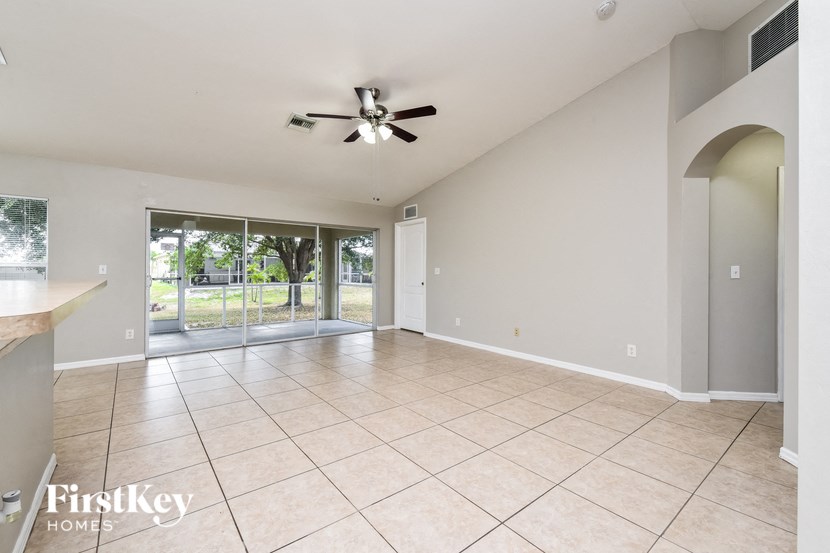 an empty living room with a ceiling fan