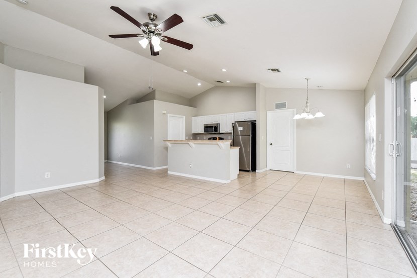 an empty kitchen and living room with a ceiling fan