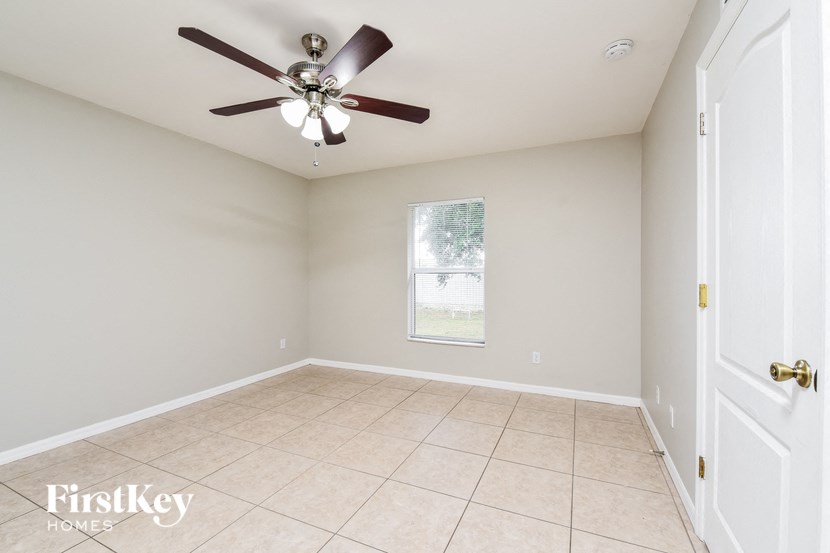 an empty room with a ceiling fan and a tiled floor